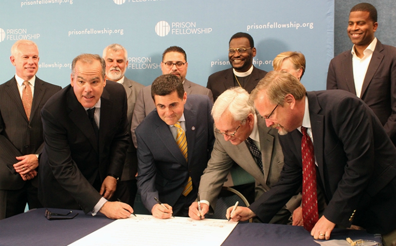 Leaders of evangelical organizations sign the "Justice Declaration," a statement by Christian leaders on criminal justice reform, in Washington, D.C., on June 20, 2017. Left to right, Prison Fellowship Ministries President James Ackerman, Southern Baptist ethicist Russell Moore, National Association of Evangelicals President Leith Anderson, and David Carlson of the Colson Center for Christian Worldview. (RNS/Adelle M. Banks)