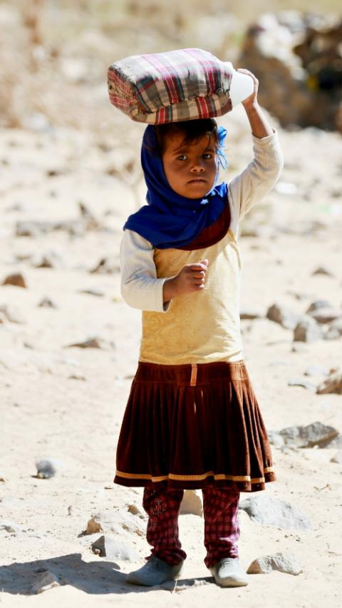 A displaced Yemeni girl carries a water container March 29 at a refugee camp located between Marib and Sanaa, Yemen. (CNS/Reuters/Ali Owidha) A displaced Yemeni girl carries a water container March 29 at a refugee camp located between Marib and Sanaa, Yemen. (CNS/Reuters/Ali Owidha)