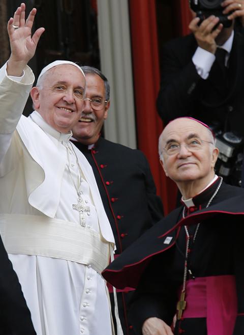 Pope Francis in 2015 waves alongside Archbishop Carlo Maria Vigano, then the apostolic nuncio to the United States, right, outside St. Patrick in the City Church in Washington. (CNS/Bob Roller)