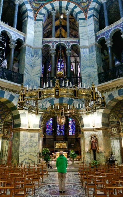 A man prays inside the cathedral in Aachen, Germany, March 25, amid the coronavirus pandemic. (CNS/Reuters/Thilo Schmuelgen)