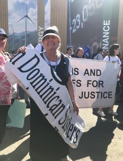 Adrian Dominican Sr. Durstyne Farnan carries a placard as she demonstrates at the central area of the conference center in Sharm el-Sheikh, Egypt. (EarthBeat photo/Doreen Ajiambo)