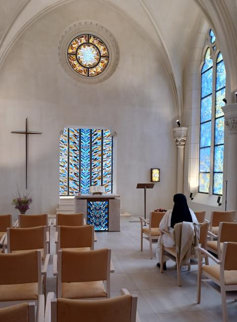 Una hermana reza, sentada y frente al altar, en la capilla de la Maison St-Charles, en París. 