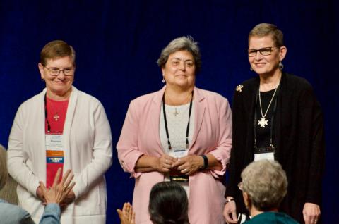 La presidenta de la Conferencia de Liderazgo de Religiosas, Hna. Maureen Geary, la expresidenta, Hna. Rebecca Ann Gemma, y la presidenta electa, Hna. Sue Ernster, son bendecidas por la asamblea el 11 de agosto, tras tomar posesión de sus cargos en la asamblea anual de la LCWR en Dallas, Texas. (Foto: Dan Stockman/GSR)