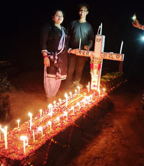 The grave of martyr Bikram Nayak. Standing by the gravesite are his wife Ashalota Nayak and their son. (Courtesy of Sujata Jena) 