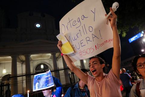 A Nicaraguan exiled in Costa Rica holds a sign that says. "Out with Ortega and Murillo! #SOSNicaragua," during the Faith and Freedom Vigil in front of the Metropolitan Cathedral of San José, Costa Rica, Aug. 19, 2022, to protest against the detention of Matagalpa Bishop Rolando Álvarez by Nicaraguan authorities. (OSV News/Reuters/Mayela López)