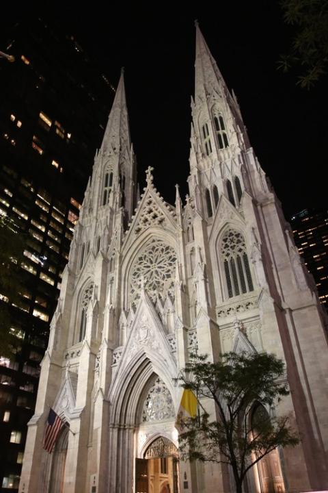 Archdiocese of New York insurance litigation, sex abuse settlements. Looming cathedral edifice lit-up against night sky