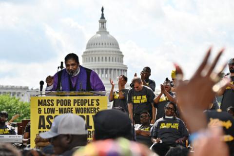 Rev. Barber speaks at lectern, Capitol building in background