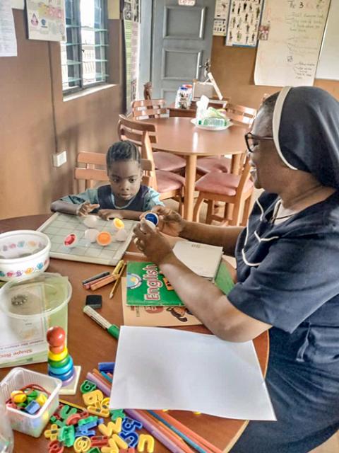 St. Louis Sr. Christie Udebor helps a student in a color-matching exercise at the Community Based Rehabilitation Center in Akure, Ondo state, Nigeria. (Courtesy of Christie Udebor)