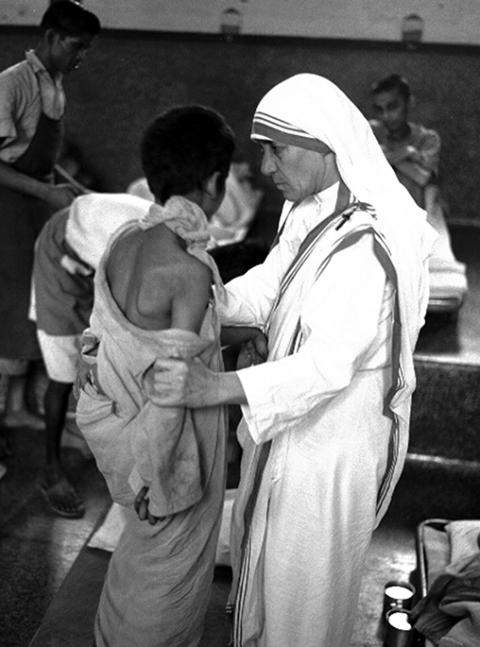 Mother Teresa of Kolkata, who brought smiles to the faces of countless sick and dying people, is pictured with a youth in an undated photo. (CNS/Courtesy of Catholic Press Photo)