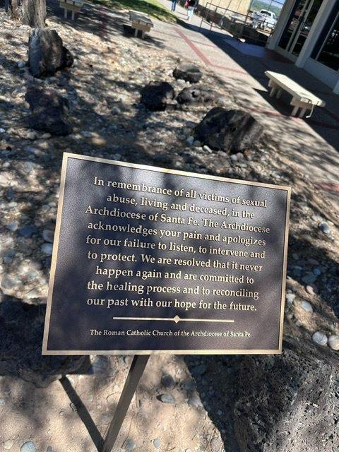 Bronze plaque pictured in small courtyard. 