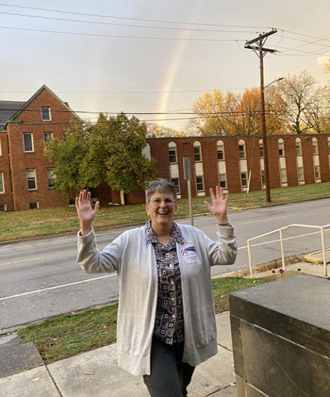 Springfield Dominican Sr. Beth Murphy takes a break from being an election judge to pose Nov. 5 in front of a rainbow over the city of Springfield, Illinois, a welcome sight after a day of heavy rain. (Courtesy of Beth Murphy)