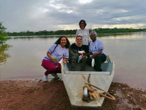 Hna. Yolanda Olivera, de pie, junto a Dalila Marques Lemos, y las hermanas Sofía Quintans Bouza y Clementine Kikadi Kwakenda, durante una visita a la comunidad indígena macuxi en Boa Vista, Roraima, Brasil, en diciembre de 2023. Al fondo, el río Blanco, que atraviesa el territorio ancestral de este pueblo originario. (Foto: cortesía Yolanda Olivera)