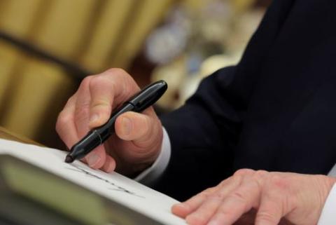 Trump signs document.