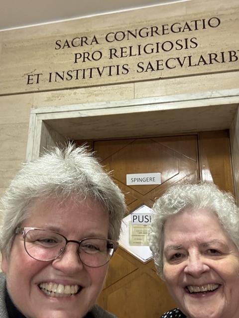 Benedictine Srs. Lynn McKenzie, left, and Esther Fangman stand outside the Sacra Congregatio pro Religiosis et Institutis Saecularibus now called the Dicastery for Institutes of Consecrated Life and Societies of Apostolic Life, to prove they were there on official business, in November 2024. (Courtesy of Lynn McKenzie)