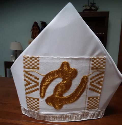 A white bishop's mitre with gold accents.