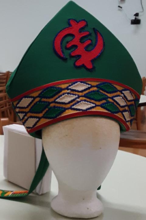 A a green mitre with red, white and gold accents designed and created by Sr. Jannette Pruitt.