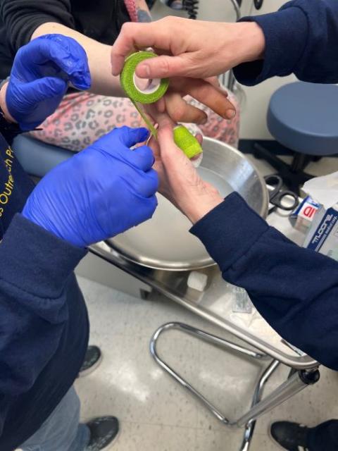 Sr. Mary Meyers takes care of a person's injured finger at the clinic at the Catholic Charities Neighborhood Center in Wheeling, West Virginia. (Courtesy of Mary Meyers)