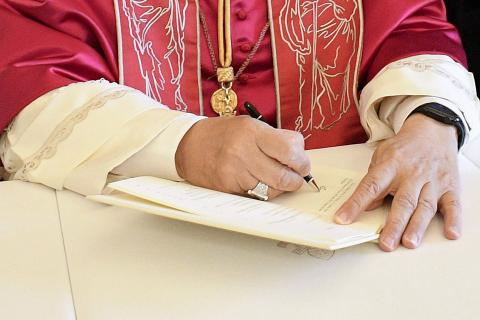 Pope Leo XIV signs his first apostolic exhortation, "Dilexi Te" ("I Have Loved You"), in the library of the Apostolic Palace at the Vatican Oct. 4, 2025, the feast of St. Francis of Assisi, as Archbishop Edgar Peña Parra, the substitute secretary for general affairs at the Vatican Secretariat of State, looks on. The exhortation was released Oct. 9. (OSV News photo/Vatican Media/CPP)