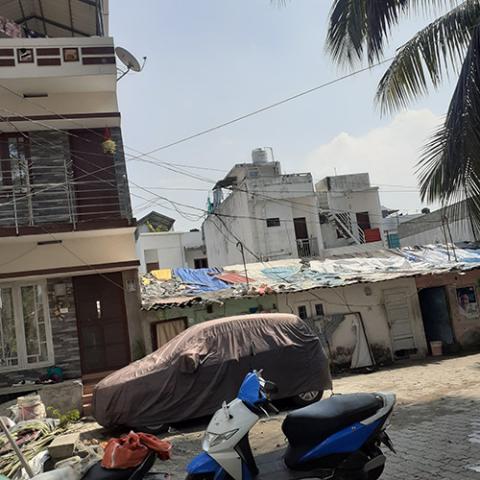 Newly built multistoried houses contrast with the original single-room tenements at Udaya Colony in Kerala state's Kochi city. The new houses ameliorate the impact of flooding and make families more united by including an internal stairway. (Rita Joseph)