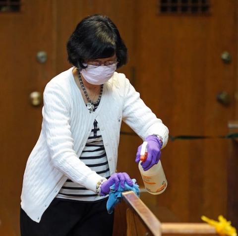 Parishioner Lucy Alibutod sanitizes pews following Mass Nov. 22 at Immaculate Conception Parish in Jamaica Estates, New York. The Passionist-run parish is located in the Diocese of Brooklyn. (CNS/Gregory A. Shemitz)