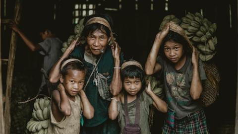 People carrying bananas (Unsplash/Zeyn Afuang)