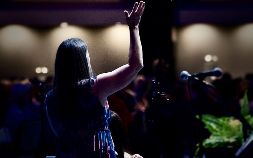 Julie Tragon, liturgist for the LCWR assembly, raises her hand in praise as CeCe Winans' song "Goodness of God" plays Aug. 15. (GSR photo/Dan Stockman)
