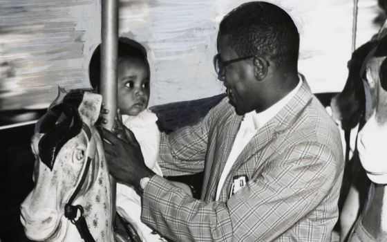 The Baltimore Sun photo of 11-month-old Sharon Langley and her father on the carousel at Gwynn Oak Amusement Park on Aug. 28, 1963, in Baltimore. (©Hearst Communications, Inc.)