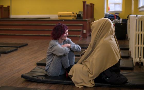 Pictured before the coronavirus pandemic, two guests talk at St. Felix Centre, a Felician-sponsored shelter in Toronto that offers a transitional home for women experiencing homelessness and also sponsors two 24-hour satellite "respite centers" all year. 