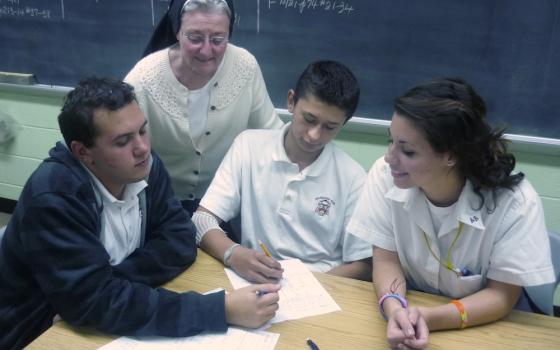 Sr. Alice Hess works with Archbishop Ryan High School students William Lightner, Sean Donnelly and Angilina DeTomasso in her classroom in the early 2000s. (Provided photo)