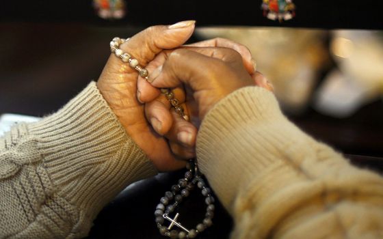 A worshipper prays a rosary at the metropolitan cathedral in Curitiba, Brazil, in this 2014 file photo. (CNS/Amr Abdallah Dalsh, Reuters)