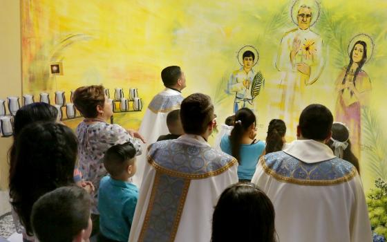 Fr. Ron Hicks, vicar general for the Chicago Archdiocese, blesses a new shrine containing a first-class relic of Blessed Oscar Romero during Mass in late May at Immaculate Conception Church in Chicago. (CNS/Chicago Catholic/Karen Callaway)