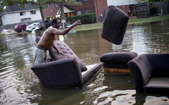 A man moves his flood-damaged sofas in Houston Sept. 3. (CNS/Reuters/Adrees Latif)