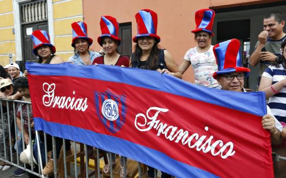 People hold a banner thanking Pope Francis along the parade route for the pope in Trujillo, Peru, Jan. 20. (CNS/Paul Haring)