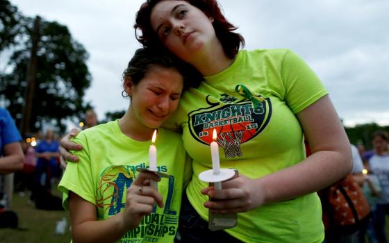 A young woman weeps during a vigil in memory of the victims killed in a shooting May 20 at Santa Fe High School in Texas. (CNS/Reuters/Jonathan Bachman)