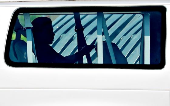 A minor sits in the back of a van July 11 as he is transported into Casa Esperanza, a federally contracted shelter in Brownsville, Texas. (CNS/Reuters/Carlos Barria)