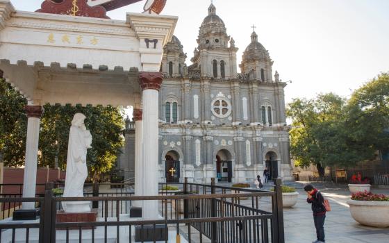 A woman prays Oct. 1 outside St. Joseph Catholic Church in Beijing. (CNS/Isaac Brekken, EPA)