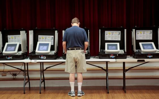 A man casts his vote in 2017 at Holy Cross Catholic Church in Tucker, Ga. (CNS/Chris Aluka Berry, Reuters)