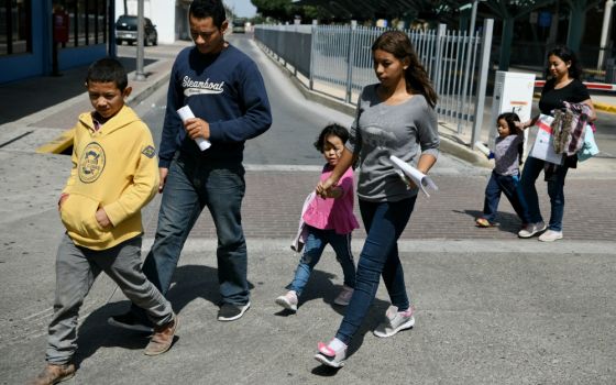 Migrant families seeking asylum walk from a bus depot to a Catholic Charities humanitarian respite center just after being released from federal detention in McAllen, Texas, July 31. (CNS/Reuters/Loren Elliott)