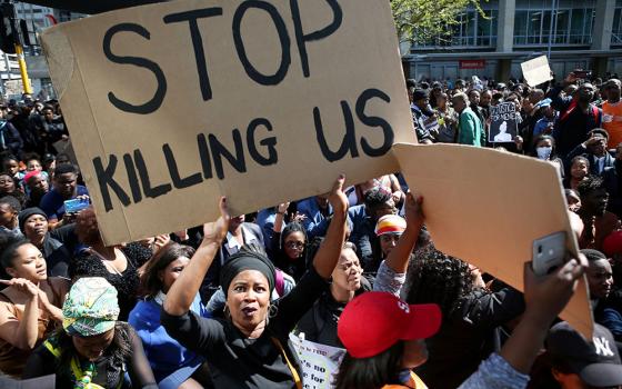 A woman holds a sign as demonstrators gather Sept. 4, 2019, at the World Economic Forum on Africa in Cape Town, South Africa, during a protest against gender-based violence. (CNS/Reuters/Sumaya Hisham)