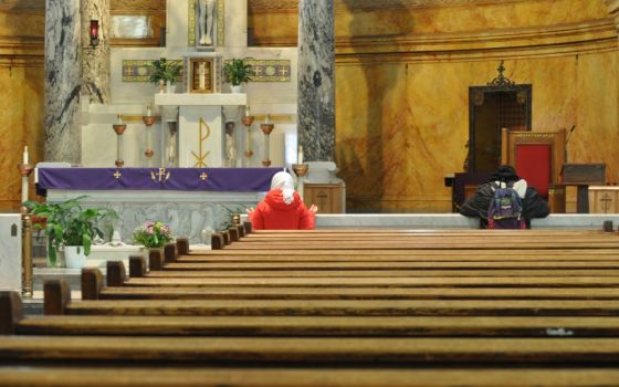 People pray in an empty St. Michael's Church in Brooklyn, New York, March 16, the first day that all Masses were suspended in the Brooklyn Diocese due to the coronavirus pandemic. (CNS/The Tablet/Ed Wilkinson) 