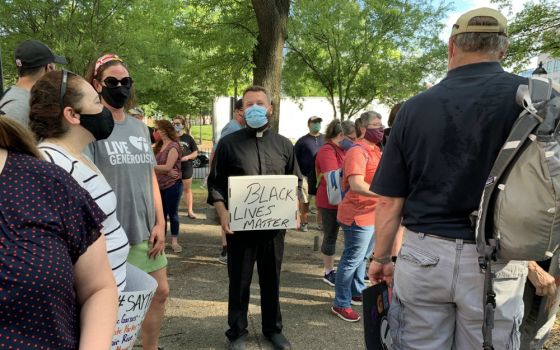 Fr. Joshua Laws, pastor of the Catholic Community of South Baltimore, holds a "Black Lives Matter" sign before the start of an interfaith prayer vigil in Baltimore June 3 to pray for justice and peace following the May 25 death of George Floyd. (CNS)