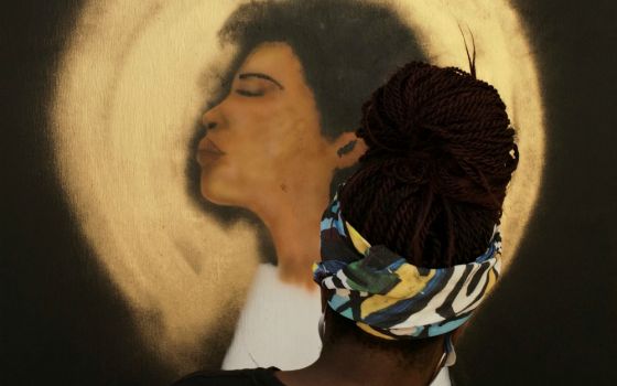 A woman in Washington paints a mural on the boarded-up windows of St. John's Episcopal Church at Black Lives Matter Plaza Sept. 5. (CNS/Reuters/Cheriss May)