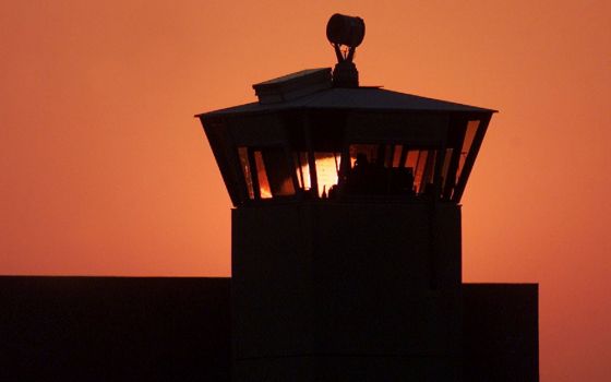 The sun sets behind one of the guard towers in a 2001 file photo at the Federal Correctional Complex in Terre Haute, Indiana, the site where the federal death penalty is carried out. (CNS/Reuters/Andy Clark)