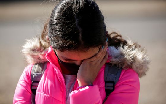 A migrant girl from Central America cries before crossing the Rio Bravo with her family in Ciudad Juárez, Mexico, Feb. 5 to request asylum in El Paso, Texas. (CNS/Reuters/Jose Luis Gonzalez)