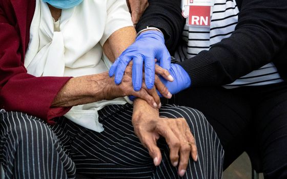 A 111-year-old woman is comforted by a nurse following her COVID-19 vaccination at IU Health Neuroscience Center March 16 in Indianapolis. (CNS/Chris Bergin, Reuters)