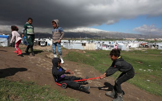 Syrian refugee children play together at an informal tent settlement in the Bekaa Valley in Lebanon March 12. (CNS/Reuters/Mohamed Azakir)