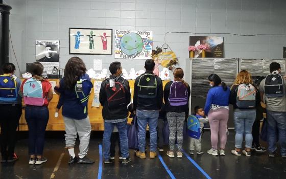 Mercy Sr. Terry Saetta, far left, and Mercy Sr. Patricia Mulderick, far right, pose May 7 at the respite center in McAllen, Texas, where they volunteered to help migrants. (CNS/Courtesy of the Sisters of Mercy)