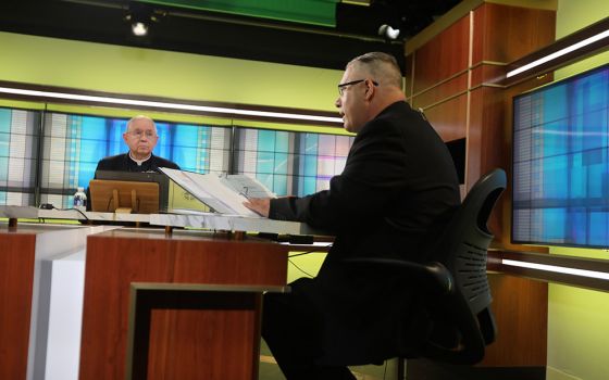 Los Angeles Archbishop José Gomez, president of the U.S. Conference of Catholic Bishops, looks on as Msgr. Jeffrey D. Burrill, the conference's general secretary, reads a message to Pope Francis June 16 at the conference headquarters in Washington. (CNS)