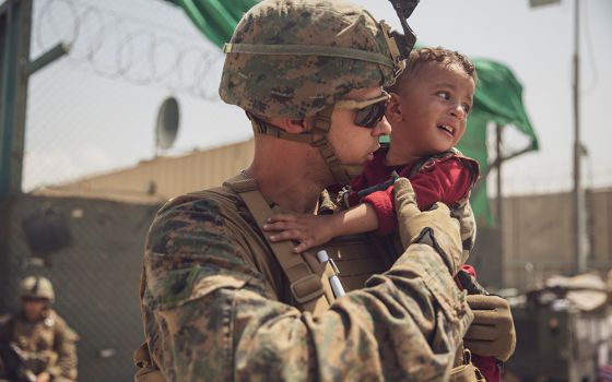 A U.S. Marine calms a toddler during an evacuation at Hamid Karzai International Airport Aug. 22 in Kabul, Afghanistan. (CNS/U.S. Marine Staff Sgt. Victor Mancilla, handout via Reuters)