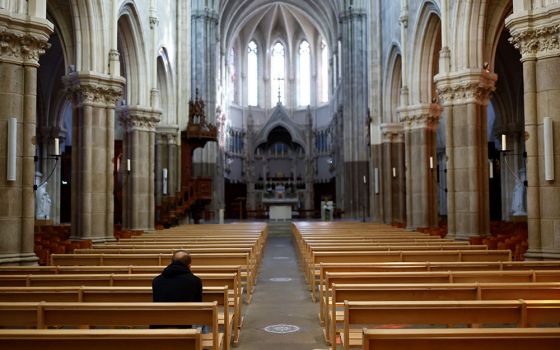 A man prays inside St. Martin Church near Nantes, France, Oct. 5. (CNS/Reuters/Stephane Mahe)